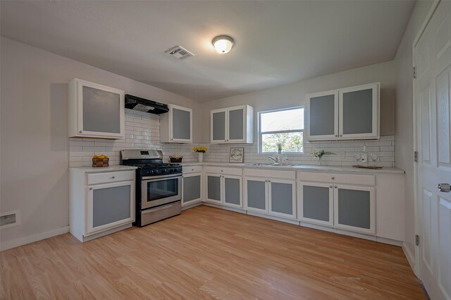 kitchen featuring gas range, white cabinetry, extractor fan, and light wood-type flooring