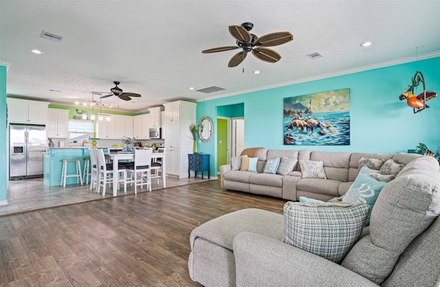 living room with ceiling fan, hardwood / wood-style floors, and crown molding