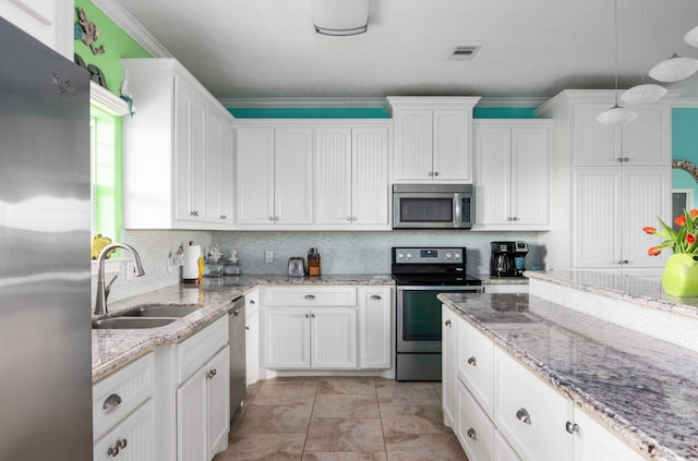 kitchen with appliances with stainless steel finishes, white cabinets, sink, decorative backsplash, and crown molding