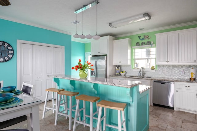 kitchen with white cabinets, sink, a center island, appliances with stainless steel finishes, and light tile patterned floors