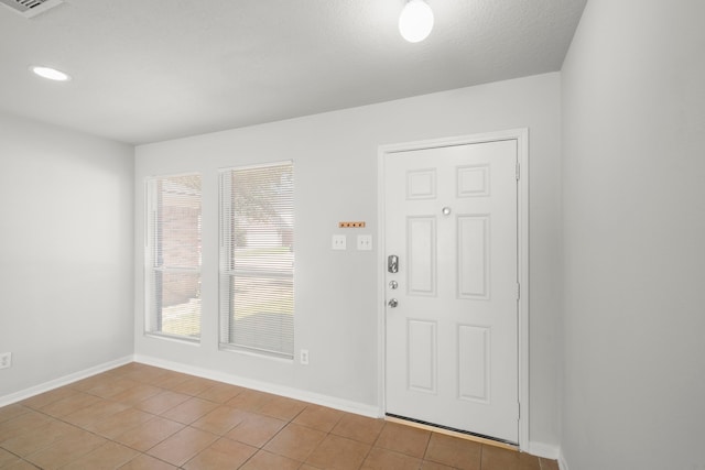 entrance foyer featuring light tile patterned flooring and plenty of natural light