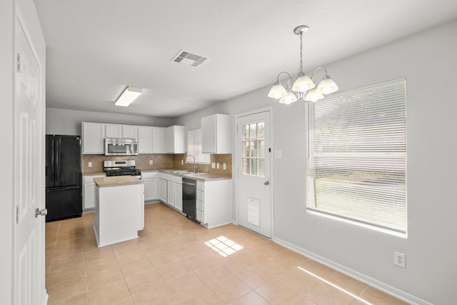 kitchen with light tile patterned flooring, sink, pendant lighting, and black appliances