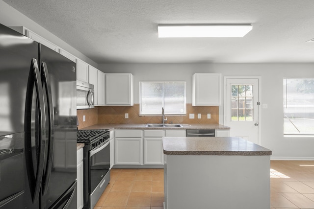 kitchen featuring light tile patterned flooring, tasteful backsplash, a kitchen island, stainless steel appliances, and sink