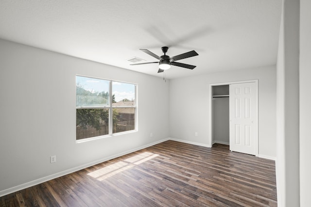 unfurnished bedroom with dark hardwood / wood-style flooring, a closet, and ceiling fan