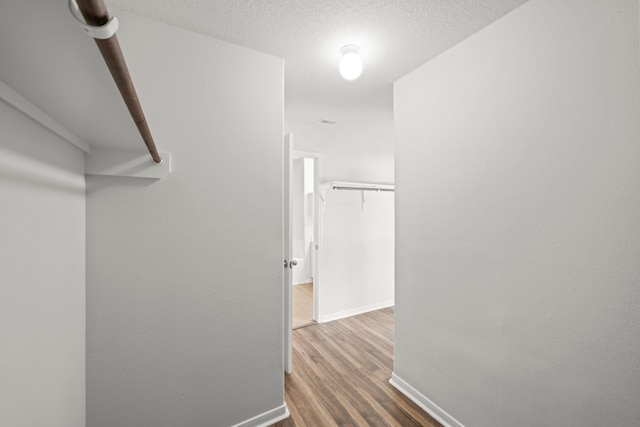 hall featuring a textured ceiling and hardwood / wood-style floors