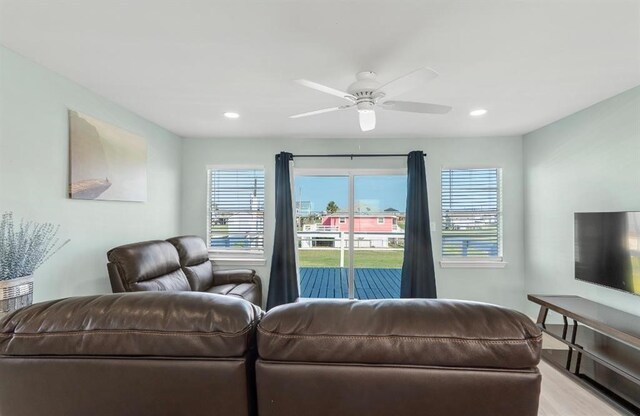 living room with light wood-type flooring and ceiling fan