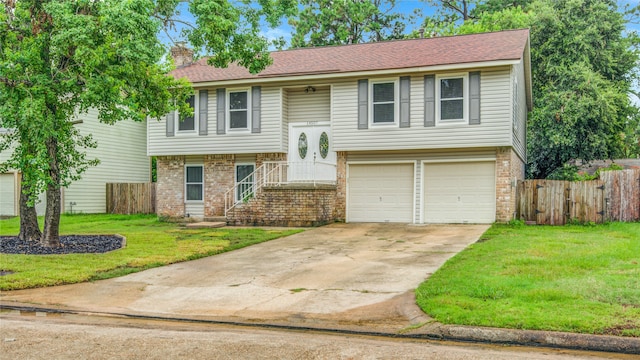 bi-level home with a garage and a front lawn