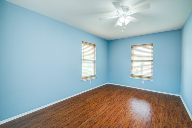 unfurnished room featuring dark wood-type flooring and a wealth of natural light