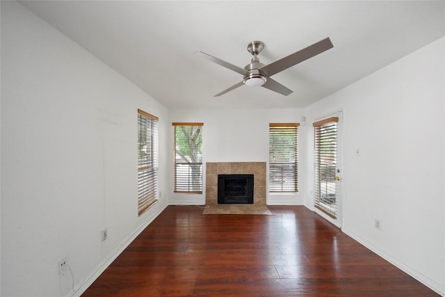 unfurnished living room with ceiling fan, a fireplace, and dark hardwood / wood-style flooring