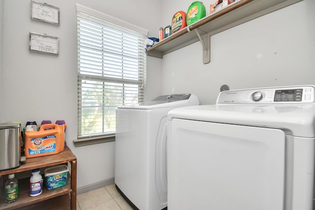 clothes washing area featuring light tile patterned flooring and separate washer and dryer