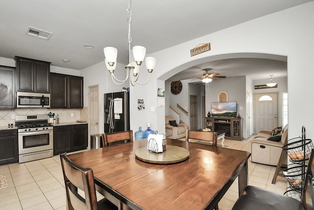 tiled dining area with ceiling fan with notable chandelier