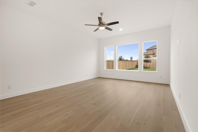 empty room with ceiling fan and light hardwood / wood-style flooring