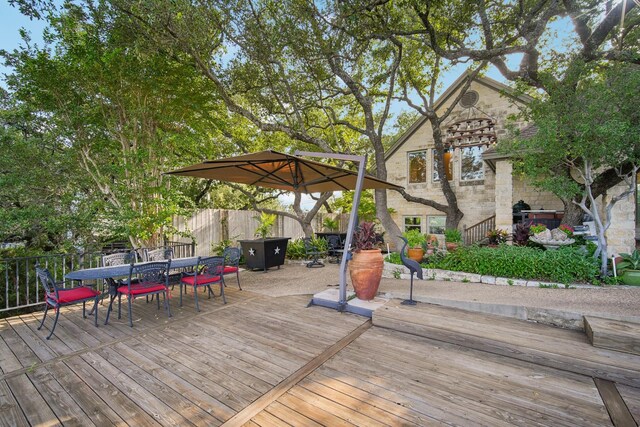 wooden terrace with outdoor dining area and fence