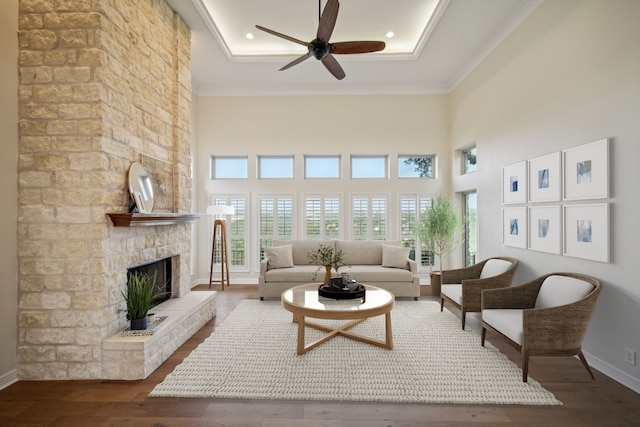 living area featuring baseboards, recessed lighting, a fireplace, wood finished floors, and a ceiling fan