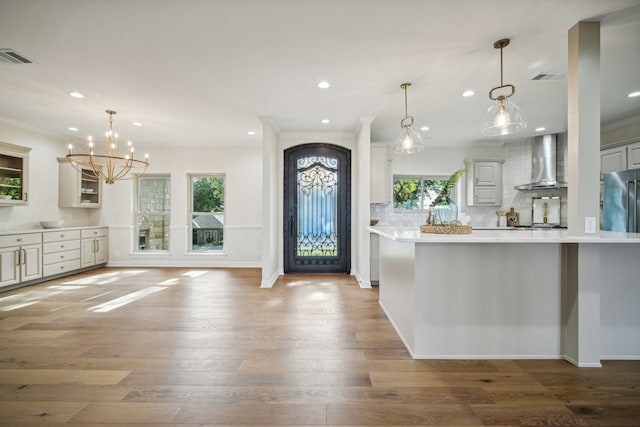 entryway with an inviting chandelier, hardwood / wood-style flooring, and crown molding