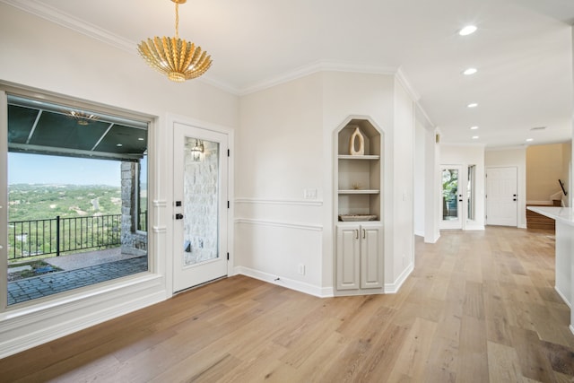 foyer featuring light wood-type flooring and ornamental molding