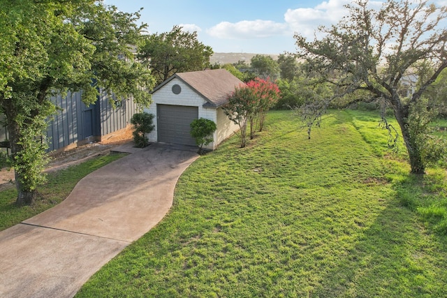 view of front of property featuring a garage, a front lawn, and an outdoor structure