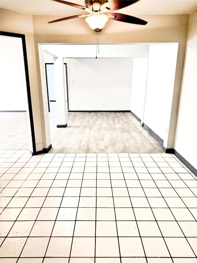 tiled spare room featuring ceiling fan