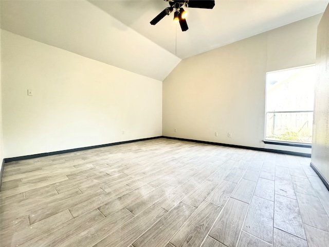 spare room featuring light hardwood / wood-style flooring, ceiling fan, and vaulted ceiling