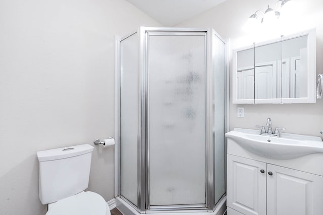 bathroom featuring toilet, vanity, and an enclosed shower