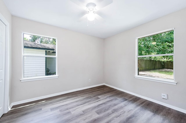 spare room with plenty of natural light, hardwood / wood-style floors, and ceiling fan