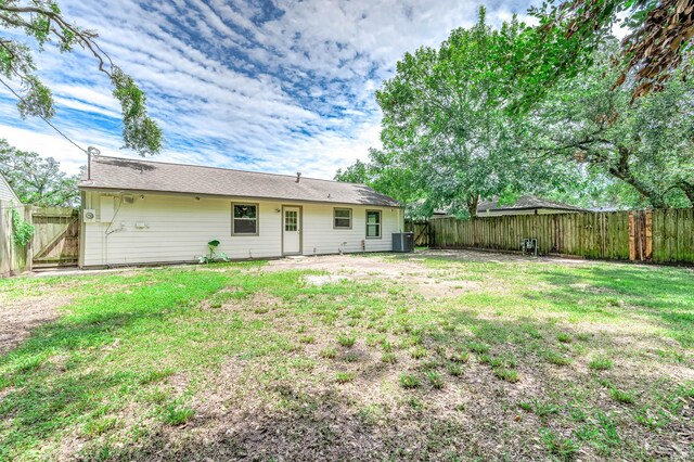 rear view of house featuring a yard