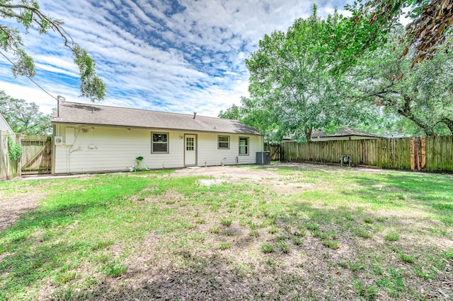 rear view of house featuring a yard and central AC unit