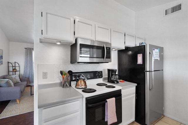 kitchen with backsplash, white cabinetry, light tile patterned flooring, and stainless steel appliances