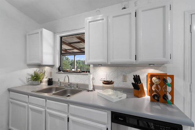 kitchen featuring sink, decorative backsplash, white cabinets, and dishwashing machine