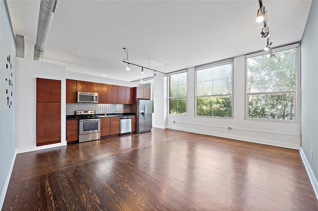 unfurnished living room with dark wood-type flooring and track lighting