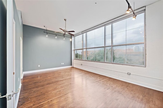 unfurnished room with wood-type flooring, rail lighting, and ceiling fan