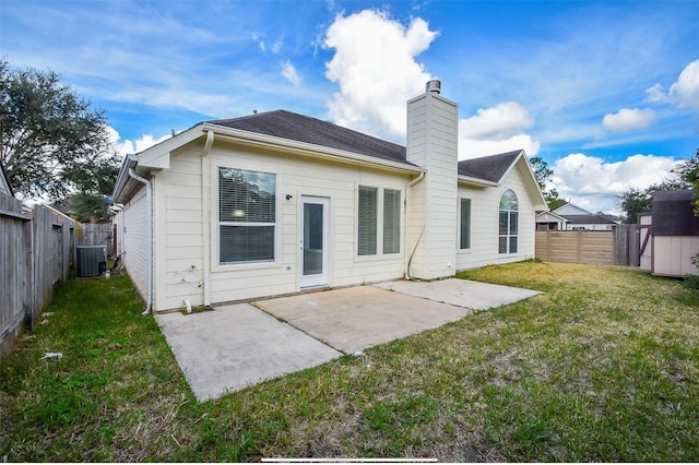 rear view of house featuring a patio area, a yard, and central AC