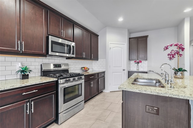 kitchen with light stone counters, stainless steel appliances, sink, and light tile patterned floors