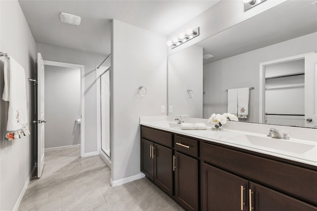 bathroom with tile patterned flooring, walk in shower, and vanity