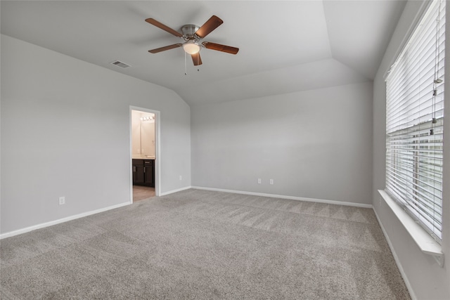 unfurnished bedroom with lofted ceiling, ceiling fan, light carpet, and ensuite bathroom