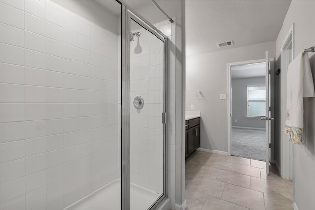 bathroom with vanity, a textured ceiling, tile patterned flooring, and a shower with door