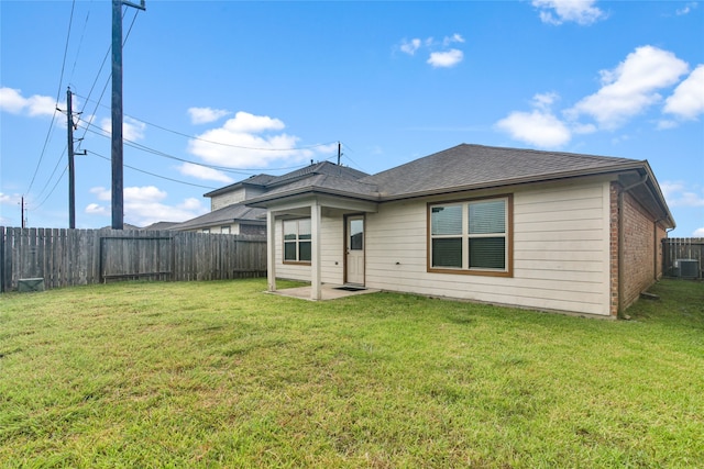 back of property with central AC and a yard