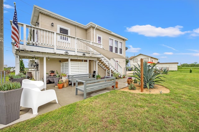 back of property featuring a yard, a wooden deck, and a patio area