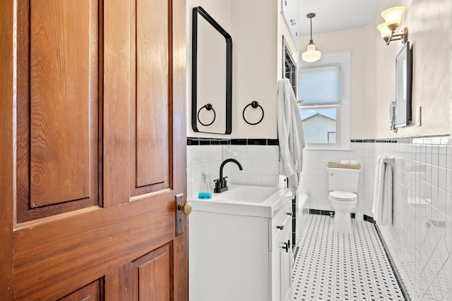 bathroom with vanity, tasteful backsplash, tile walls, toilet, and tile patterned flooring