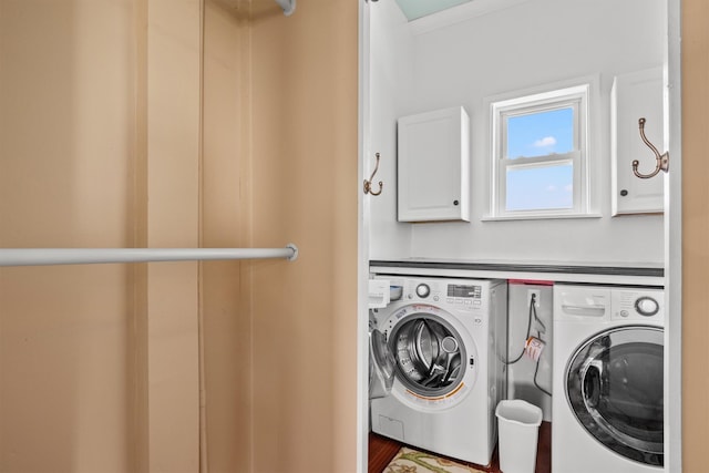 laundry room featuring cabinets, washer and dryer, and hardwood / wood-style floors