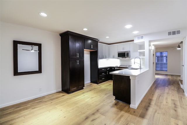 kitchen featuring light hardwood / wood-style floors, tasteful backsplash, sink, and ceiling fan