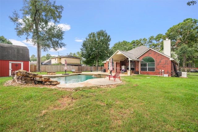 view of pool featuring a lawn, a storage shed, and a patio