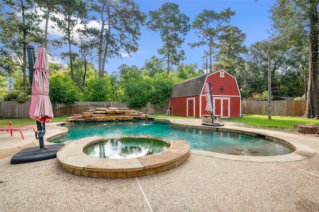 view of pool with an in ground hot tub and a shed