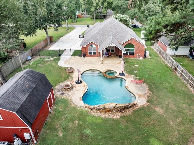 view of pool featuring a storage unit, a lawn, and a patio area