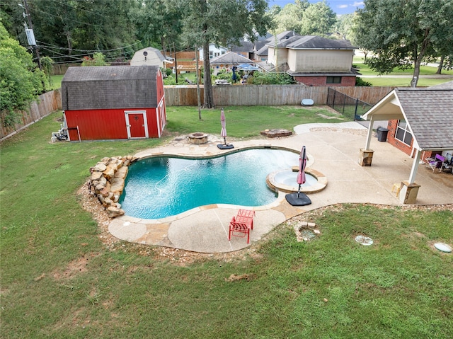 view of pool with a shed, a yard, and a patio area