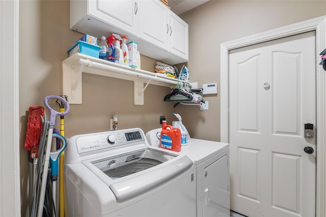 washroom featuring cabinets and washing machine and clothes dryer