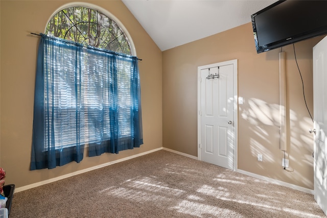 spare room featuring carpet floors and lofted ceiling