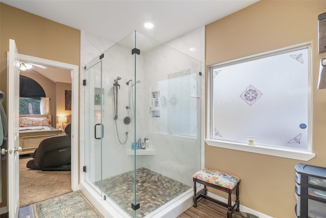 bathroom featuring ceiling fan and an enclosed shower