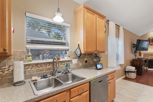 kitchen featuring dishwasher, sink, hanging light fixtures, light hardwood / wood-style flooring, and backsplash