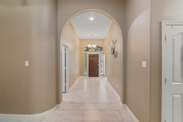 hallway featuring light tile patterned floors and a chandelier